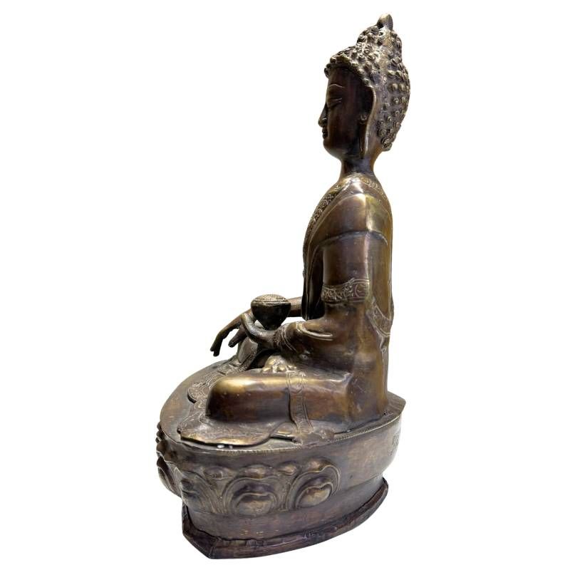 Detail van antieke bronzen Medicijnboeddha met rustige expressie