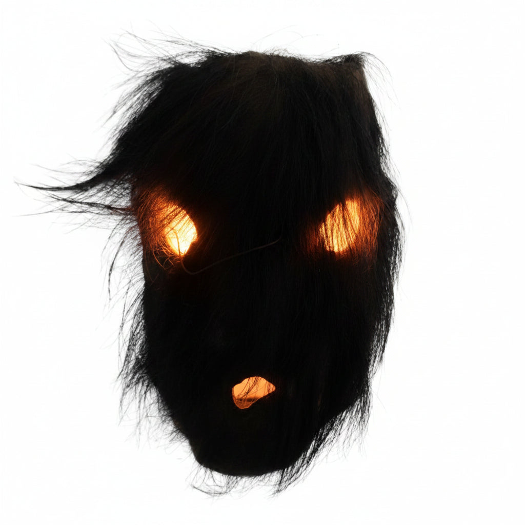 Direkter Blick auf die rituelle Maske aus Nepal mit dem dichten Haar aus organischem schwarzem Yakhaar über den Augen- und Mundöffnungen.