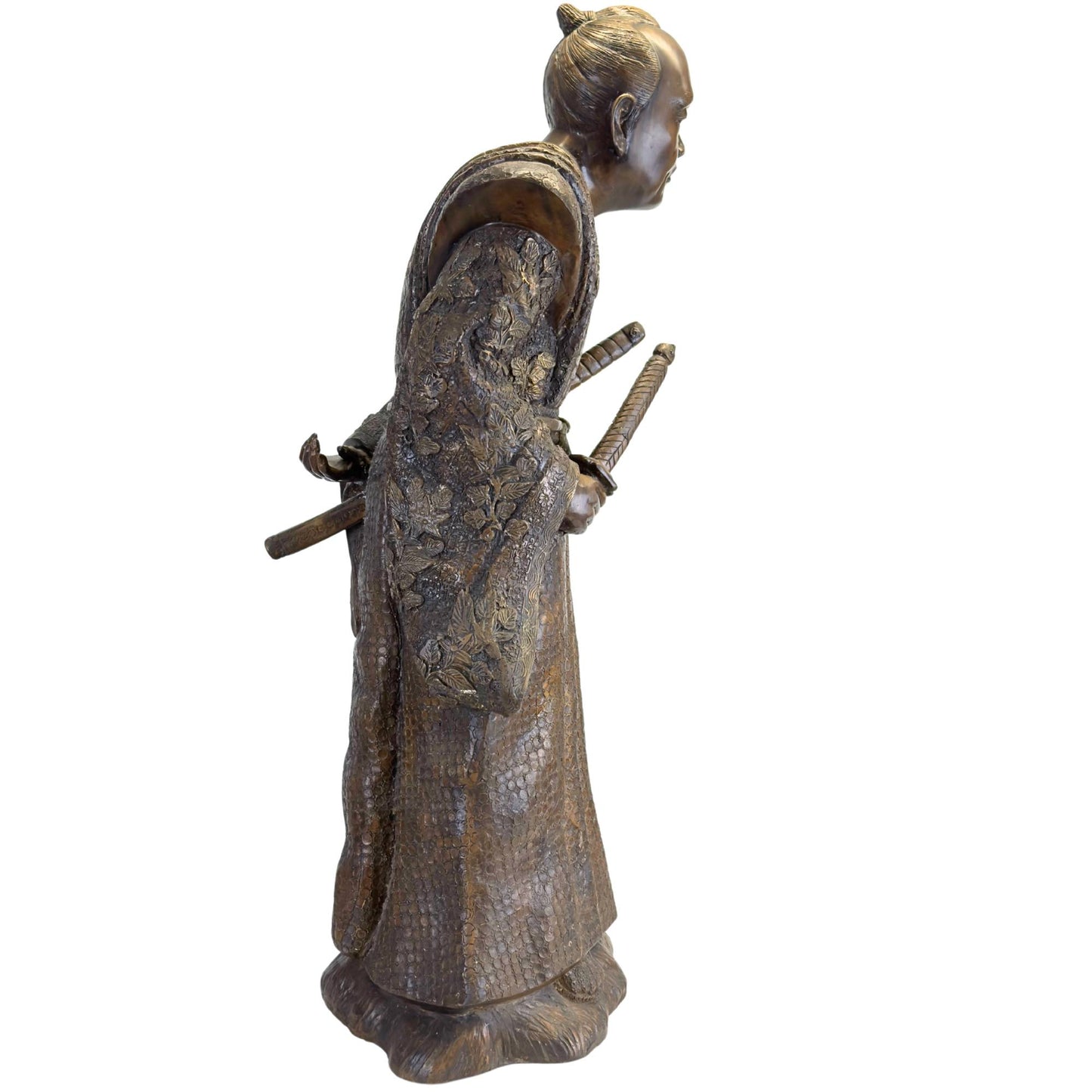 Nahaufnahme der Schwertgriffe von Katana und Wakizashi, die im Obi-Gürtel der Bronzestatue stecken.