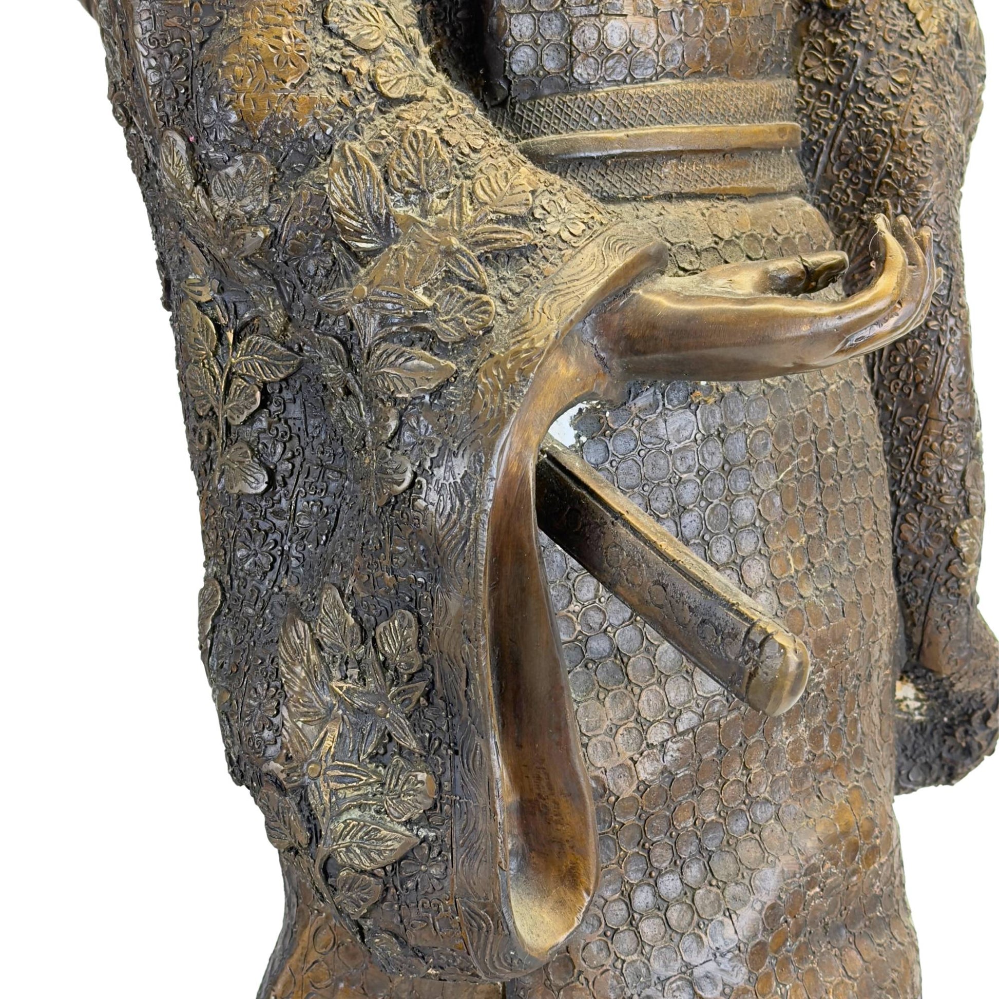 Makroaufnahme der geöffneten Ärmel, die das feine Reliefmuster mit floralen Motiven und den Griff des Wakizashi-Schwertes zeigt.