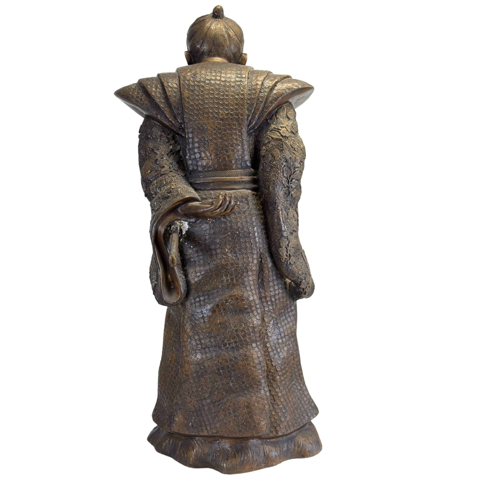 Die massive Bronzestatue eines Samurai mit ihrer tief kastanienbraunen Patina zeigt die vollständige Rückansicht.