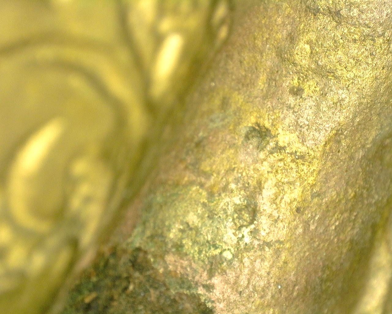 Nahaufnahme der feuervergoldeten Bronzeoberfläche mit natürlicher Oxidation und Gebrauchsspuren.