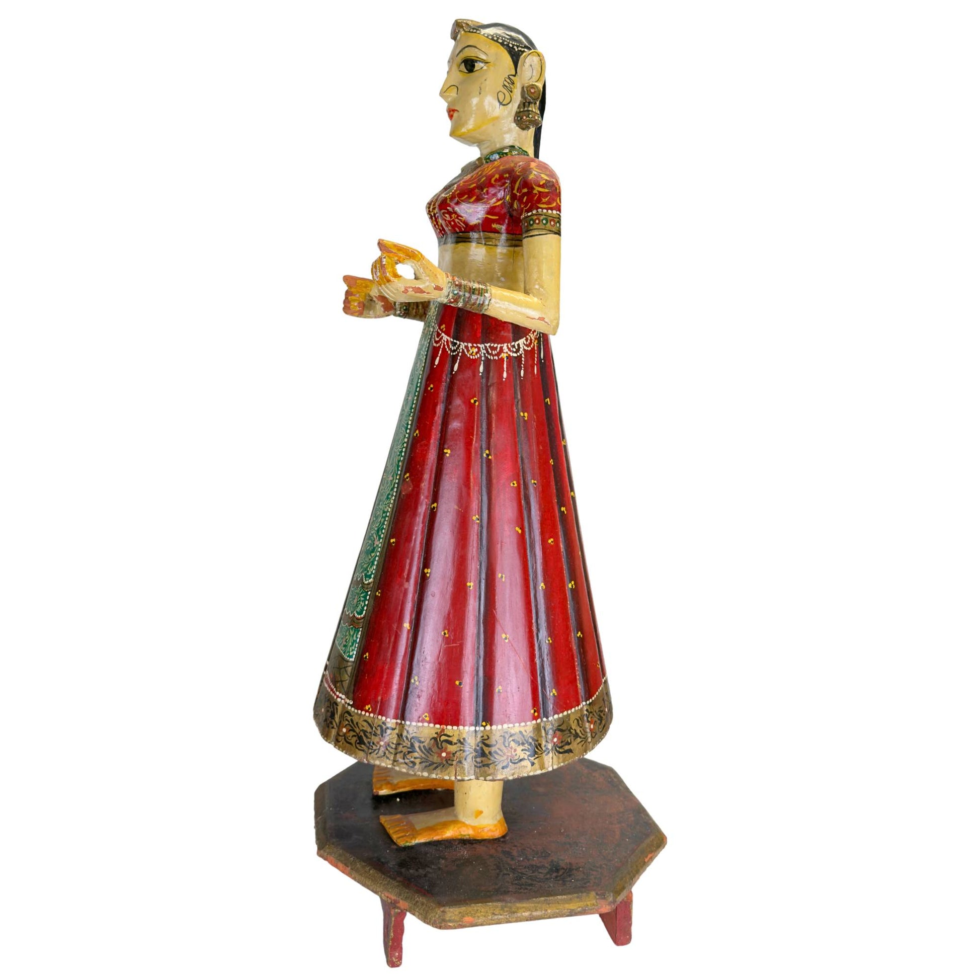 Handgeschilderde Chaniya Choli kleding op Indiaas houten beeld met rode lak, goudkleurige patronen en groene baan