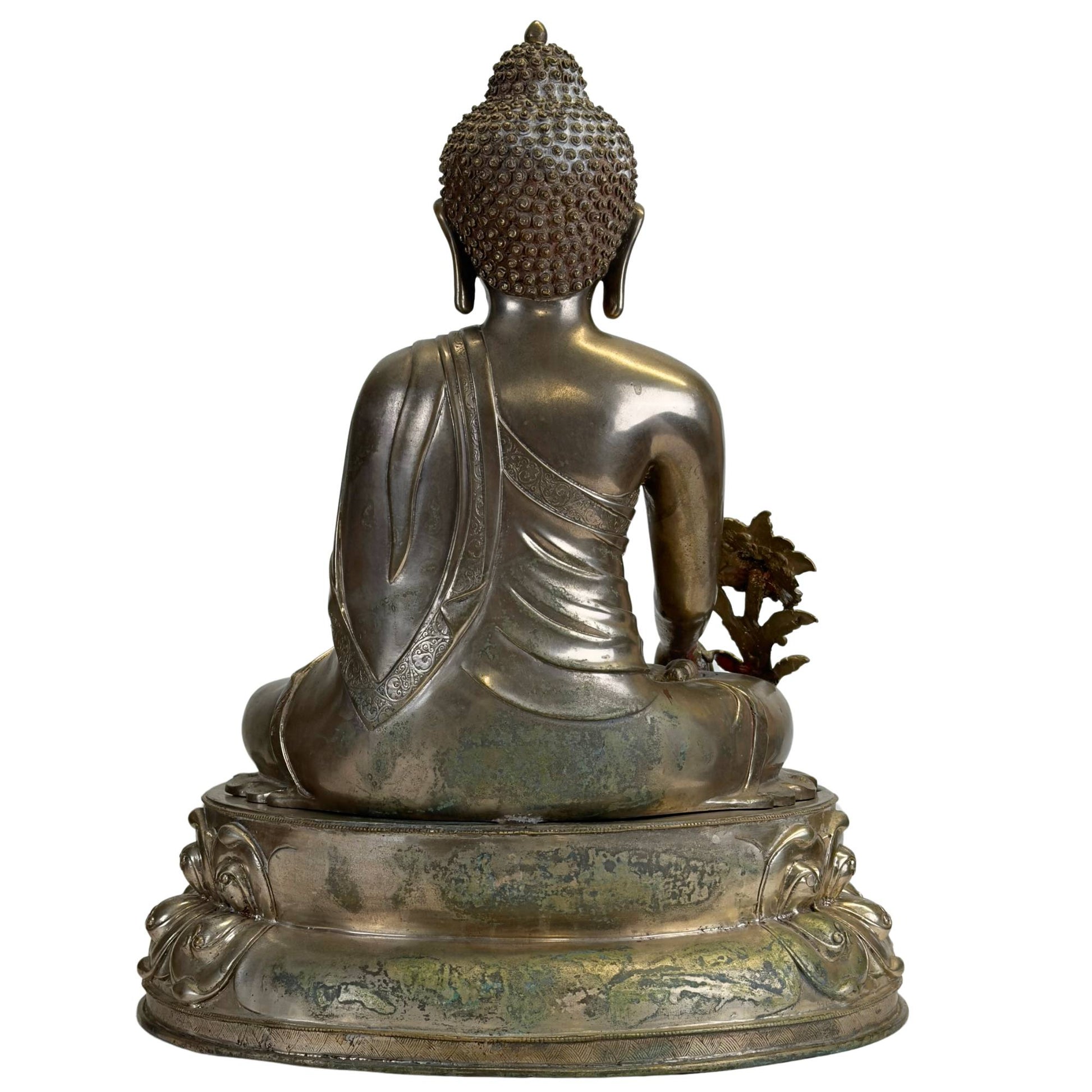 Rückseite eines antiken Newar Bhaisajyaguru aus versilberter Bronze auf einem zweiteiligen Lotusthron, mit natürlicher Patina, Gebrauchsspuren und einer fein gravierten Mönchsrobe auf der Rückseite.