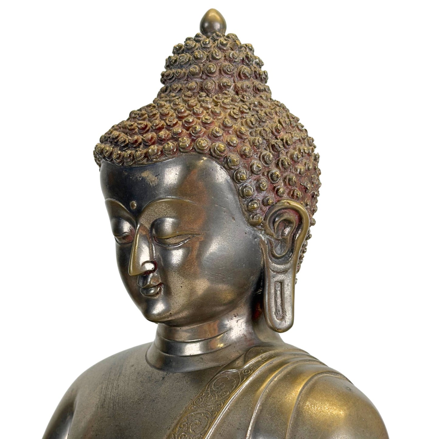 Schräges Detail des Gesichts eines antiken Newar Bhaisajyaguru aus versilberter Bronze mit feinen mandelförmigen Augen, weichen Lippen, langen Ohrläppchen, charakteristischen Haarlocken und natürlichen Gebrauchsspuren, die mit einer Statue aus dem 14. bis 15. Jahrhundert übereinstimmen.