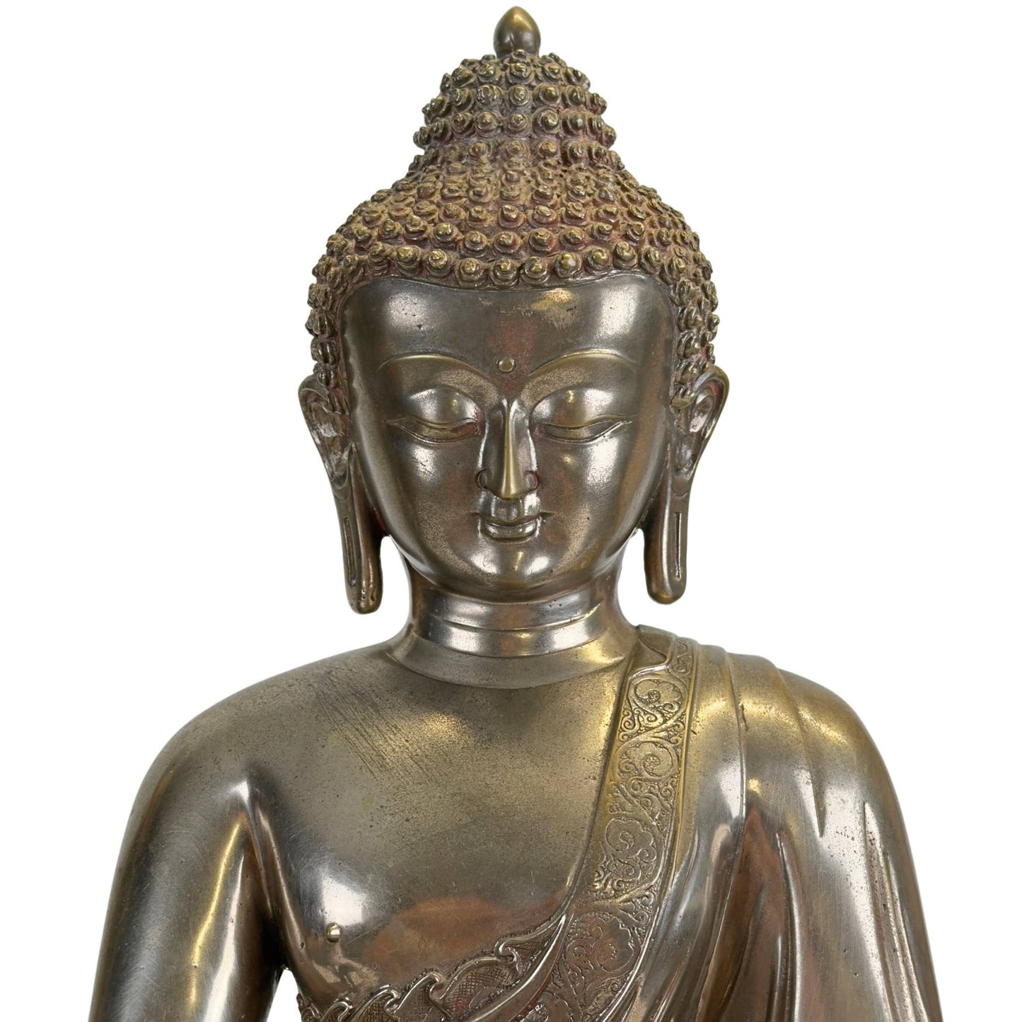 Detail des Gesichts eines antiken Newar Bhaisajyaguru aus versilberter Bronze mit heiterem Ausdruck, mandelförmigen Augen, fein modellierten Lippen, Urna und charakteristischen Haarlocken mit natürlicher Abnutzung und Patina.