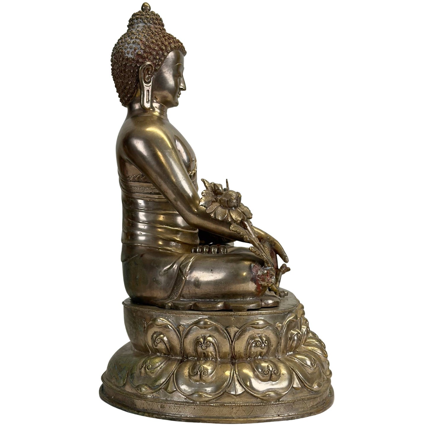 Ansicht von links eines antiken Newar Bhaisajyaguru aus versilberter Bronze auf einem reich verzierten Doppellotusthron mit einer Heilpflanze und natürlicher Patina.